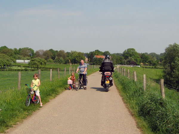 Fietsers aan de kant voor een motor