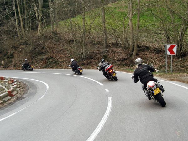 Rijtje motorrijders door de bocht