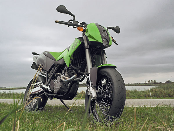 Groene KTM Duke, op een dijk