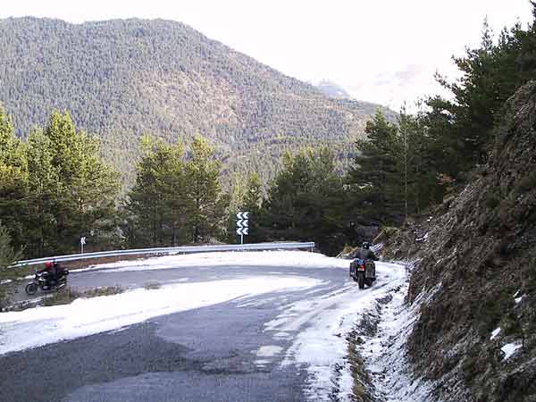 Twee motoren naar beneden door een besneeuwde haarspeldbocht