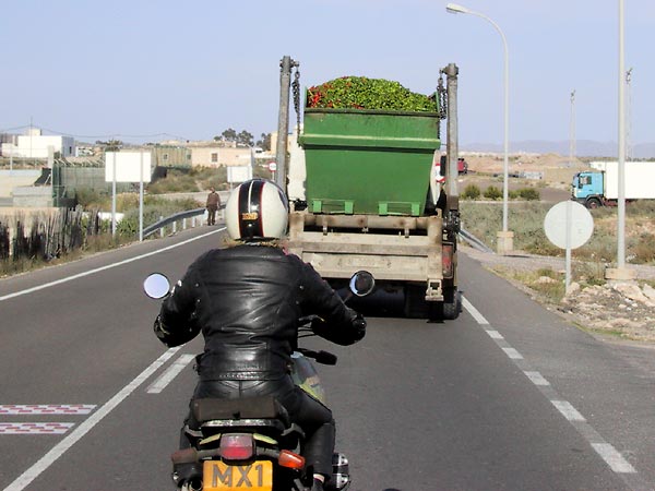 Motor rijdt achter met paprika's beladen vrachtwagen