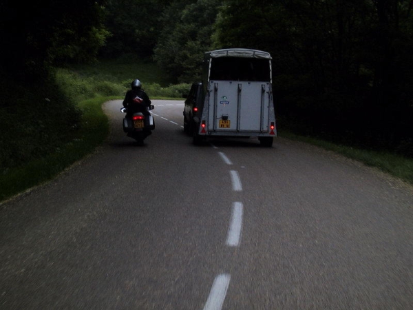 Motorrijder haalt auto met aanhanger in