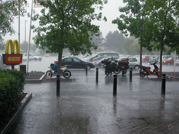 Twee motoren op straat in de stromende regen