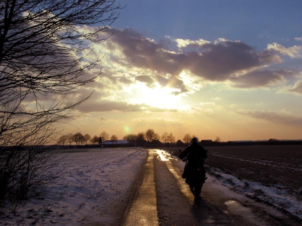 Motorrijder en ondergaande zon